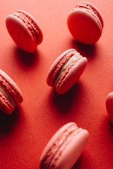 Composition of delicious pink macaroons on red table sweet dessert