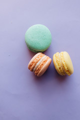 Composition of delicious macaroons on purple background