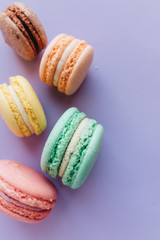 Composition of delicious macaroons on purple background