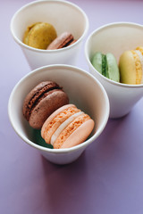 Composition of delicious macaroons on purple background
