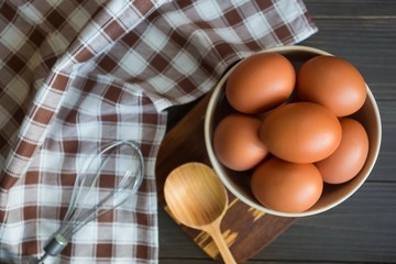 set of products and items for breakfast. orange eggs, an iron nimbus and a wooden spoon lie next to...