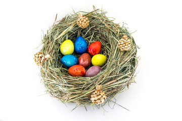Fototapeta na wymiar colored easter quail eggs in grass nest with bumps