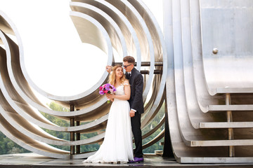Beautiful wedding couple posing in near big structure