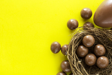 Chocolate eggs in bird nest , Easter holiday decorations , Easter concept background. Eggs hunt.