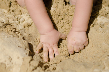 the child is digging in the sandbox
