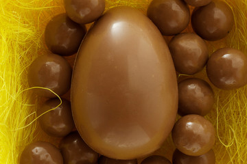 Chocolate eggs in bird nest , Easter holiday decorations , Easter concept background. Eggs hunt.