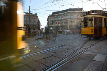 passaggio di tram in piazza cordusio a milano al tramonto