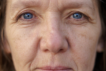 Cropped face of a blue-eyed middle-aged woman