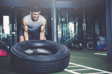 workout concept; young man practicing workout in class ; feeling commitment and patience to weight lifting with big tires