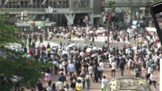 TOKYO,  JAPAN : SMARTPHONE and SHIBUYA SCRAMBLE CROSSINNG background.  Image of many people using smartphone.