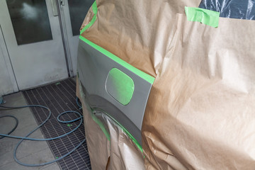 Partial painting of the side element fender and wing with fuel tank flap of the body of a beige SUV...