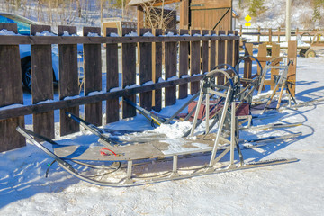 Old wooden dog sled on snow ground at dog sledding service place.