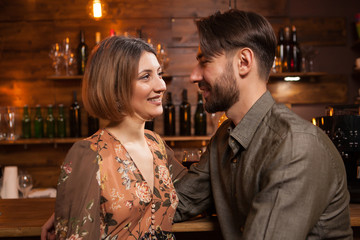 Young man laughing while looking in his wife eyes on a night out