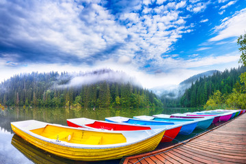 Boats on majestic mountain lake Lacul Rosu or Red Lake or Killer Lake
