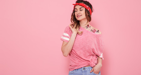 Portrait of a hipster girl with tattoo, isolated on pink background
