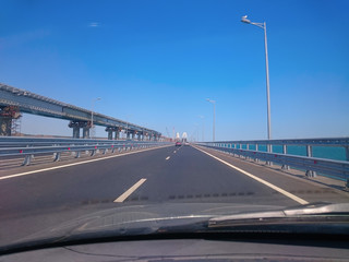 Fototapeta na wymiar View through the windshield of a moving car. Crimea, Russia - June, 8, 2018: Travel on the Crimean bridge during its construction. View from the car