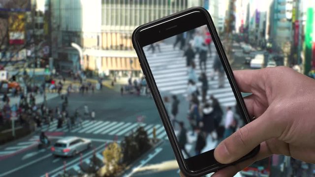 TOKYO,  JAPAN : SMARTPHONE and SHIBUYA SCRAMBLE CROSSINNG background.  Image of many people using smartphone.