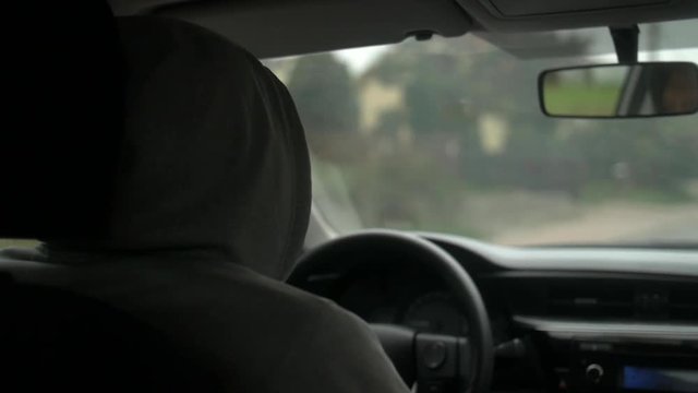 Shot of the men driving a car in countryside.