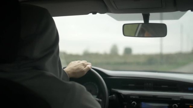 Shot of the men driving a car in countryside.