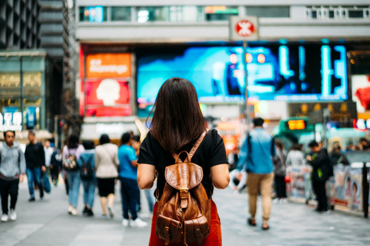Young woman traveler traveling into Tsim Sha Tsui street market in Hong Kong China