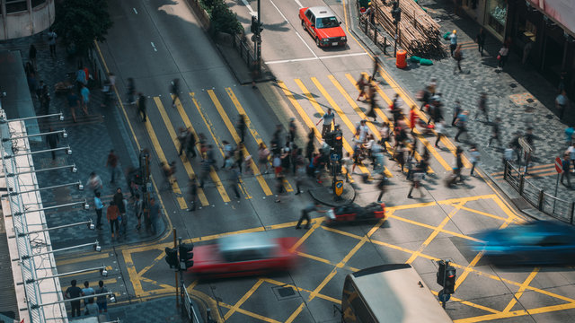 People and taxi cabs crossing a very busy crossroads in Tsim Sha Tsui district Hong Kong, China