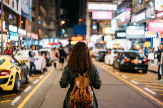 Young woman traveler traveling into Mongkok street market at night in Hong Kong China