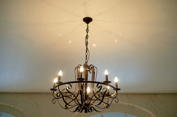 Wrought iron chandelier on the ceiling. Loft style