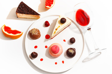 Gourmet desserts and grapefruit slices on a white plate. Top view.