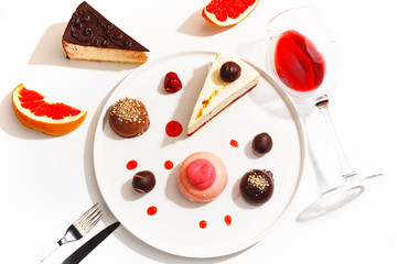 Gourmet desserts and grapefruit slices on a white plate. Top view.