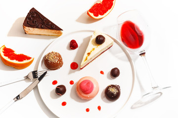 Gourmet desserts and grapefruit slices on a white plate. Top view.