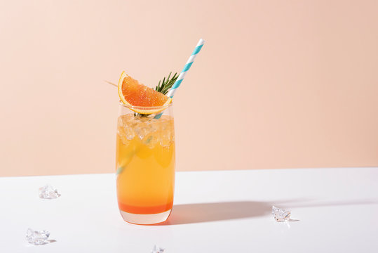 Cold and refreshing orange punch cocktail with orange slice on color background. summer drink.
