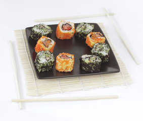 different types of Maki sushi on a black plate