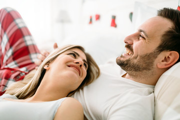 Fototapeta premium Portrait of young loving couple in bedroom