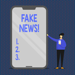 Conceptual hand writing showing Fake News. Concept meaning false stories that appear to spread on internet using other media Man Presenting Huge Smartphone while Holding Another Mobile