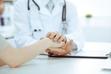 Hand of doctor reassuring her female patient. Medicine and health care concept