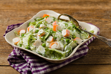Crab sticks salad with peas, cucumber and mayonnaise.
