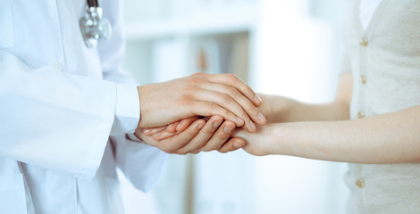 Hand of doctor reassuring her female patient. Medicine and health care concept