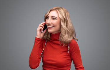 Cheerful female having smartphone conversation