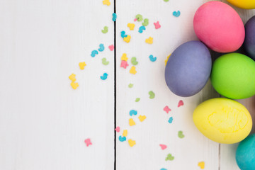 Pastel Easter eggs on rustic whote wooden table