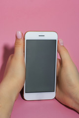 Phone in hand on pink background