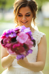 Beautiful bride holding bouquet of flowers in hands