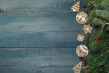 Christmas gingerbread on a blue wooden table decorated with branches of spruce. A Symbol Of Christmas. Festive food. The gingerbread man. Table decoration for the holiday. Christmas card. Empty space