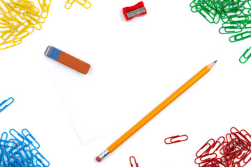 Pencil, eraser, sharpener, paper clips lie in different angles of the sheet on a white background....