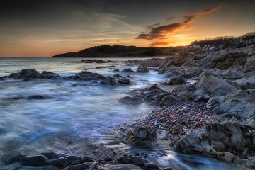 Rotherslade Bay sunset Incoming sea on the beautiful rocky coastline of Rotherslade Bay, a small bay in South Gower next to the more famous Langland Bay in Swansea, South Wales, UK