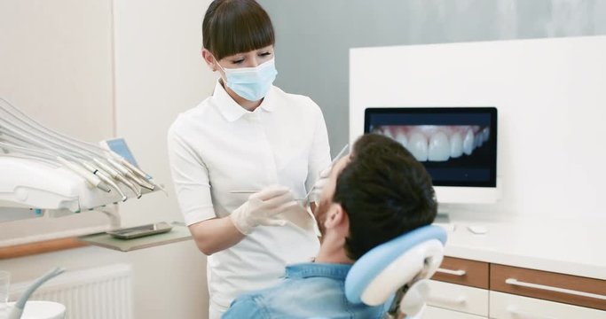 Dentists with a patient during a dental intervention to man