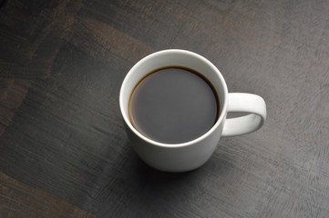 Obraz na płótnie Canvas Cup of coffee on black wood table