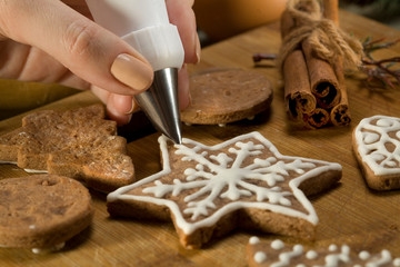 Beautiful Christmas cakes. Glaze. The icing. Decoration icing gingerbread. Beautiful Christmas cakes. Glaze. Decoration icing gingerbread. Women's hand decorated with icing protein