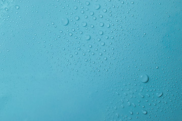 Drops of water on a blue glass texture background