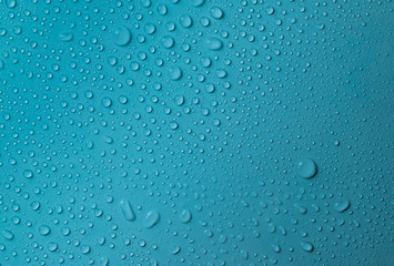 Drops of water on a blue glass texture background