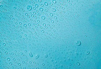 Drops of water on a blue glass texture background